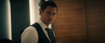 Movie still from “Gen V” (2023), created by Eric Kripke – A person wearing a vest and tie; Close Up shot, Over the shoulder angle