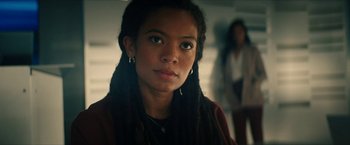 Movie still from “Gen V” (2023), created by Eric Kripke – A woman with dreadlocks is looking at the camera; Close Up shot, Over the shoulder angle