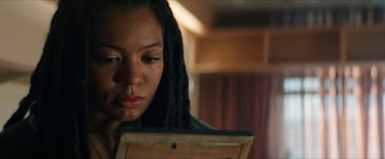 Movie still from “Gen V” (2023), created by Eric Kripke – A woman with dreads looking down at a book; Close Up shot, Low angle