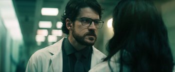 Movie still from “Gen V” (2023), created by Eric Kripke – A man wearing glasses and a lab coat; Close Up shot, Over the shoulder angle