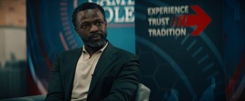 Movie still from “Gen V” (2023), created by Eric Kripke – A man sitting in front of an advertising sign; Close Up shot, Over the shoulder angle