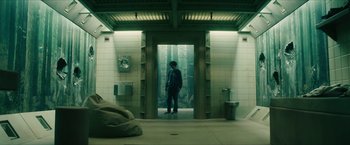 Movie still from “Gen V” (2023), created by Eric Kripke – A man standing in a doorway of a building; Wide shot, Low angle