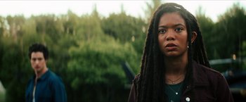 Movie still from “Gen V” (2023), created by Eric Kripke – A woman with dreads standing in front of trees; Close Up shot, Over the shoulder angle