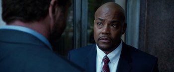 Movie still from “Geostorm” (2017), directed by Dean Devlin – A man wearing a suit and tie talking to another man wearing a suit and tie; Close Up shot, Over the shoulder angle