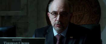 Movie still from “Geostorm” (2017), directed by Dean Devlin – A man in a suit and tie looking at the camera; Close Up shot, Over the shoulder angle