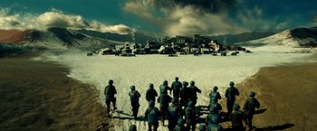 Movie still from “Geostorm” (2017), directed by Dean Devlin – A group of soldiers standing on top of a snow covered field; Extreme Wide shot, High angle