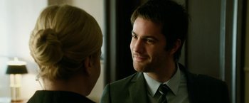 Movie still from “Geostorm” (2017), directed by Dean Devlin – A man in a business suit talking to a woman in a suit; Close Up shot, Over the shoulder angle