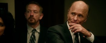 Movie still from “Geostorm” (2017), directed by Dean Devlin – A man in a suit and tie sitting next to another man in a suit and tie; Close Up shot, Over the shoulder angle