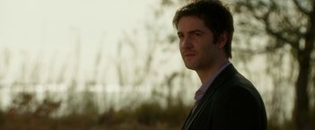 Movie still from “Geostorm” (2017), directed by Dean Devlin – A person wearing a suit and tie; Close Up shot, Over the shoulder angle