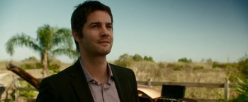 Movie still from “Geostorm” (2017), directed by Dean Devlin – A man wearing a suit and tie looking to his left; Close Up shot, Over the shoulder angle