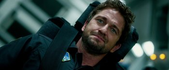 Movie still from “Geostorm” (2017), directed by Dean Devlin – A person wearing a suit and tie; Close Up shot, Over the shoulder angle