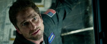 Movie still from “Geostorm” (2017), directed by Dean Devlin – A person wearing an american flag jacket; Close Up shot, Overhead angle