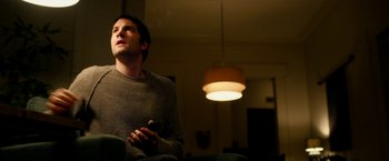 Movie still from “Geostorm” (2017), directed by Dean Devlin – A man sitting in a chair holding a remote control; Medium shot, Low angle