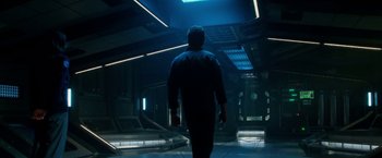 Movie still from “Geostorm” (2017), directed by Dean Devlin – A man walking in a dark room with a light on; Wide shot, Low angle