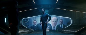 Movie still from “Geostorm” (2017), directed by Dean Devlin – A man standing in front of a wall with a picture on it; Medium shot, Over the shoulder angle
