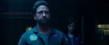 Movie still from “Geostorm” (2017), directed by Dean Devlin – A man and a woman standing next to each other in the dark; Close Up shot, Low angle