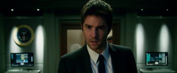 Movie still from “Geostorm” (2017), directed by Dean Devlin – A person wearing a suit and tie; Close Up shot, Over the shoulder angle