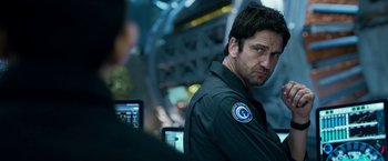 Movie still from “Geostorm” (2017), directed by Dean Devlin – A person wearing a uniform; Close Up shot, Over the shoulder angle