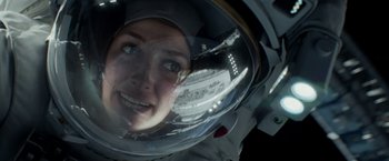 Movie still from “Geostorm” (2017), directed by Dean Devlin – A woman in a space suit looking into a mirror; Close Up shot, Overhead angle