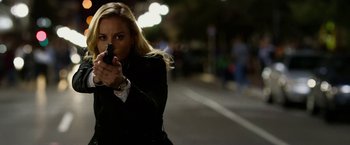 Movie still from “Geostorm” (2017), directed by Dean Devlin – A beautiful blond woman holding a gun in her hand; Close Up shot, Over the shoulder angle