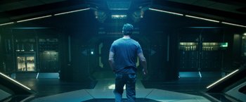 Movie still from “Geostorm” (2017), directed by Dean Devlin – A man standing in front of an entrance to a building; Wide shot, Low angle