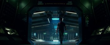 Movie still from “Geostorm” (2017), directed by Dean Devlin – A man walking down a hallway in a building; Wide shot, Low angle