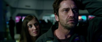 Movie still from “Geostorm” (2017), directed by Dean Devlin – A man and a woman looking at the camera; Close Up shot, Over the shoulder angle
