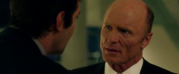 Movie still from “Geostorm” (2017), directed by Dean Devlin – An older man wearing a suit and tie talking to a younger man wearing a tie; Close Up shot, Over the shoulder angle