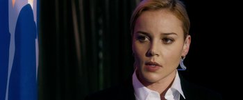 Movie still from “Geostorm” (2017), directed by Dean Devlin – A person wearing a suit and tie; Close Up shot, Over the shoulder angle