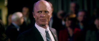 Movie still from “Geostorm” (2017), directed by Dean Devlin – An older man wearing a suit and tie; Close Up shot, Low angle