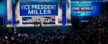 Movie still from “Geostorm” (2017), directed by Dean Devlin – A crowd of people sitting in front of a large screen; Extreme Wide shot, Low angle