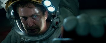 Movie still from “Geostorm” (2017), directed by Dean Devlin – A person in a space suit; Close Up shot, Over the shoulder angle