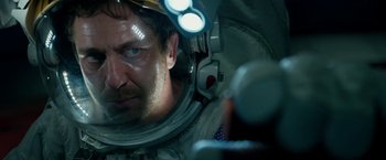 Movie still from “Geostorm” (2017), directed by Dean Devlin – A person in a space suit; Close Up shot, Over the shoulder angle