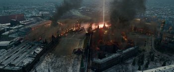 Movie still from “Geostorm” (2017), directed by Dean Devlin – An aerial view of a large city with a lot of smoke; Extreme Wide shot, Overhead angle