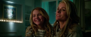 Movie still from “Geostorm” (2017), directed by Dean Devlin – A woman and a girl smiling for the camera; Close Up shot, Low angle