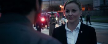Movie still from “Geostorm” (2017), directed by Dean Devlin – A woman in a black jacket is standing in front of a crowd of onlookers; Close Up shot, Over the shoulder angle