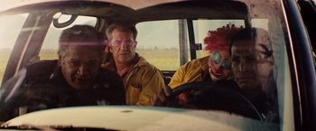 Movie still from “Get the Gringo” (2012), directed by Adrian Grunberg – A man and a woman in a car with a clown; Medium shot, Over the shoulder angle
