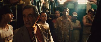 Movie still from “Get the Gringo” (2012), directed by Adrian Grunberg – A group of men standing next to each other in a room; Medium shot, Over the shoulder angle