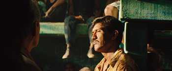 Movie still from “Get the Gringo” (2012), directed by Adrian Grunberg – A person sitting on a bench; Close Up shot, Low angle