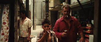Movie still from “Get the Gringo” (2012), directed by Adrian Grunberg – A man and a boy are standing in the street smoking; Medium shot, Low angle