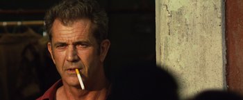 Movie still from “Get the Gringo” (2012), directed by Adrian Grunberg – A person with a cigarette in his mouth; Close Up shot, Over the shoulder angle