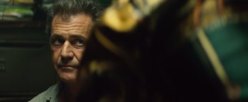 Movie still from “Get the Gringo” (2012), directed by Adrian Grunberg – An older man looking at the camera through a window; Close Up shot, Over the shoulder angle