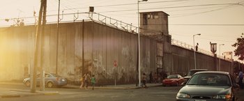 Movie still from “Get the Gringo” (2012), directed by Adrian Grunberg – A group of people walking down a street near a building; Extreme Wide shot, Low angle