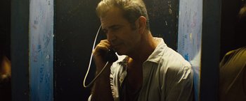 Movie still from “Get the Gringo” (2012), directed by Adrian Grunberg – A man talking on a phone while holding a cord; Close Up shot, Low angle