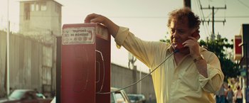 Movie still from “Get the Gringo” (2012), directed by Adrian Grunberg – A man is talking on the phone while standing next to a phone booth; Close Up shot, Low angle