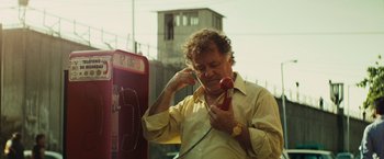 Movie still from “Get the Gringo” (2012), directed by Adrian Grunberg – A man holding a red phone up to his ear; Close Up shot, Low angle
