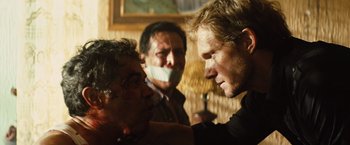 Movie still from “Get the Gringo” (2012), directed by Adrian Grunberg – A group of men standing next to each other in a room; Close Up shot, Over the shoulder angle
