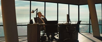 Movie still from “Get the Gringo” (2012), directed by Adrian Grunberg – A man sitting at a desk in front of a window; Wide shot, Low angle