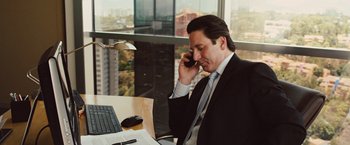 Movie still from “Get the Gringo” (2012), directed by Adrian Grunberg – A man sitting at a desk talking on a cell phone; Medium shot, High angle