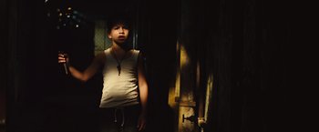 Movie still from “Get the Gringo” (2012), directed by Adrian Grunberg – A young man standing in front of an open door; Medium shot, Low angle